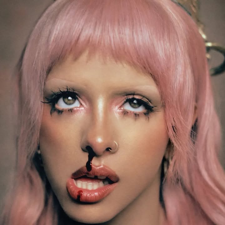 Imagem mostrando uma lista de indicações com o título “Melanie Martinez Submete Hades a Vários Grammys 2027”; não fornece detalhes visuais adicionais na imagem.