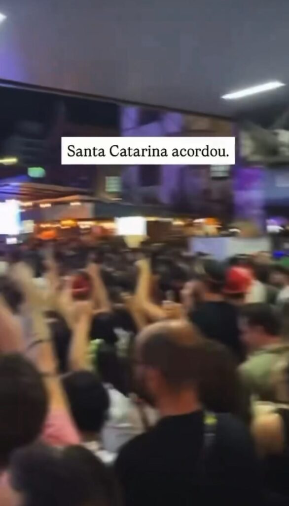Homem com expressão surpresa ao lado de um rosto de lula, em cenário urbano, com bandeira ou cores relacionadas ao apoio a Lula13.