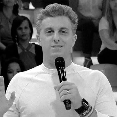 Imagem de uma celebridade brasileira com estilo de apresentador, inspirado na apresentadora Ellen DeGeneres, sugerindo semelança entre Huck e DeGeneres.